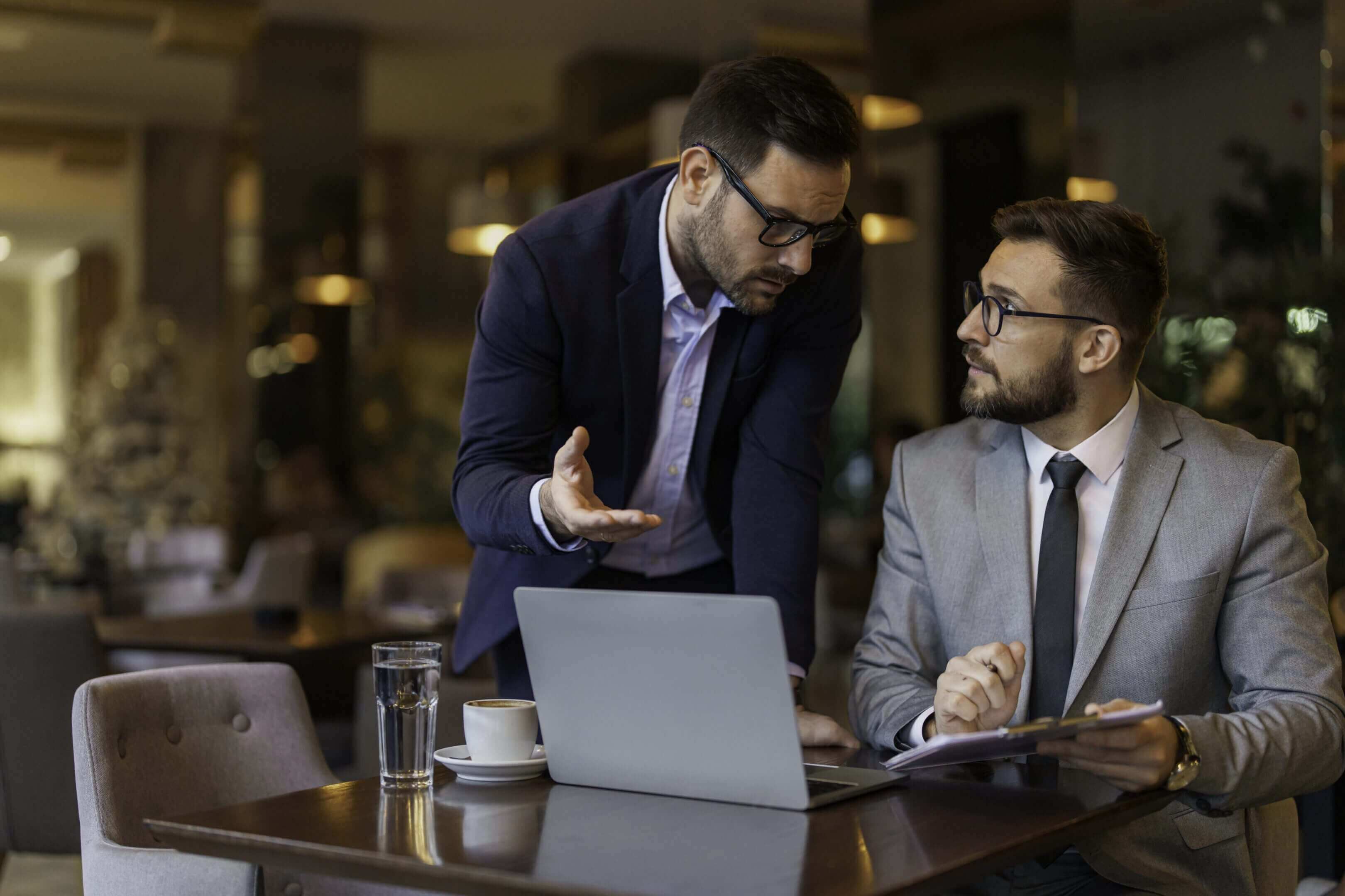 Two businessmen discussing work in an office setting.