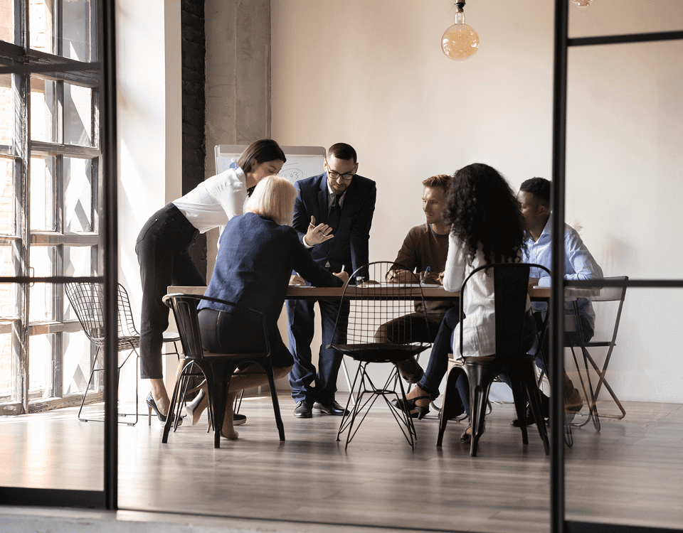 A diverse team collaborates around a table in a modern office.